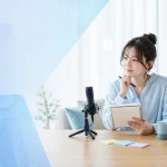 配信前にスマートフォンとマイクを前に企画を考えるライバー